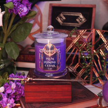 Load image into Gallery viewer, Purple candle labeled 'Meera Octavia -Plum Jasmine Cedar' on a wooden stand with a gold sword and decorative elements.