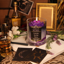 Load image into Gallery viewer, A soy candle with a purple rose on a black, grey and violet candle. The label reads "Planeshift Candles - Sciel - lavender, sea salt and vetiver"
