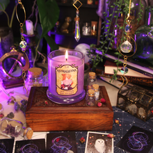 Load image into Gallery viewer, Lit purple Astralaeyna candle in a clear glass jar. Label reads " Planeshift Candles - Astralaeyna, Lilac, Lavender, Rose, Parchment"
