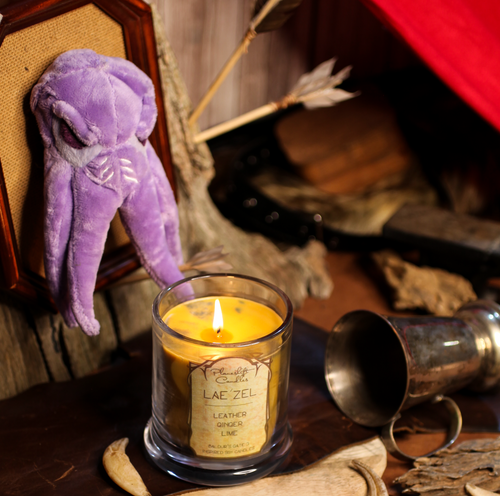 A lit yellow soy candle with spots of grey wax spreading through it. Label reads 