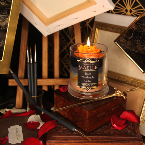 A lit orange wax rose sits on black, grey and orange tinted candle. The label reads 