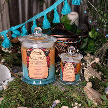 Load image into Gallery viewer, Large and Small Melinoe candles in orange and teal wax poured in clear glass jars with lids.
